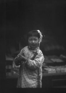 Young girl walking down the street, looking into the camera, Chinatown, San Francisco, c1896-c1906. Creator: Arnold Genthe