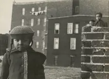 Young girl, with other children in background, in a vacant lot behind some tenement..., 1947 - 1951. Creator: Romulo Lachatanere