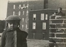 Young girl, with other children in background, in a vacant lot behind some tenement..., 1947 - 1951. Creator: Romulo Lachatanere