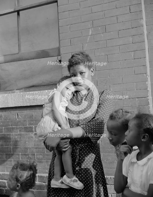 Young girl with her sister who live on Seaton Road, Washington, D.C., 1942. Creator: Gordon Parks.