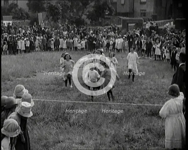 Young Girls Finishing a Running Race in a Field, 1920. Creator: British Pathe Ltd.