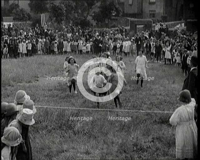 Young Girls Finishing a Running Race in a Field, 1920. Creator: British Pathe Ltd.