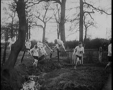 Young Female Civilians Wearing Sport Outfits Running Across a Field Jumping over Water in a..., 1920 Creator: British Pathe Ltd