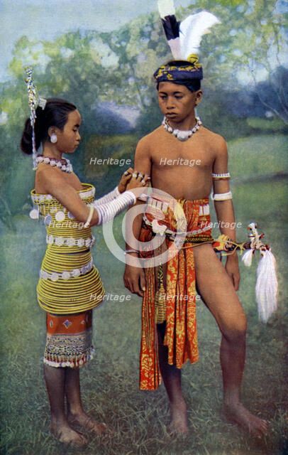 'Young Iban or Sea Dayaks people in gala attire, Borneo', 1922. Artist: Dr Charles Hose