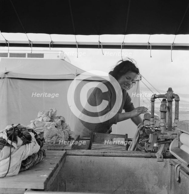 Young migrant girl makes use of facilities..., Merrill FSA camp, Klamath County, Oregon, 1939. Creator: Dorothea Lange.