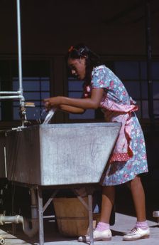Young woman at the community laundry on Saturday afternoon, FSA ... camp, Robstown, Tex., 1942. Creator: Arthur Rothstein