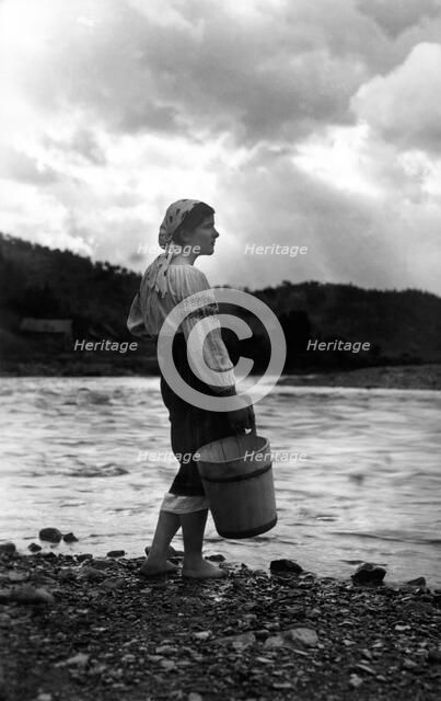Young woman with a bucket, Bistrita Valley, Moldavia, north-east Romania, c1920-c1945. Artist: Adolph Chevalier