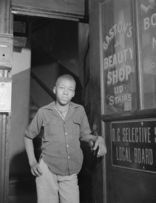 Youth waiting for a newspaper delivery truck, Washington, D.C., 1942. Creator: Gordon Parks