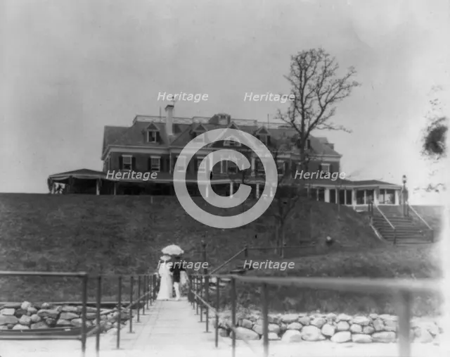 Yacht club, Oyster Bay, Long Island, N.Y. Couple walking on far end of bridge or pier, 1905. Creator: Frances Benjamin Johnston.
