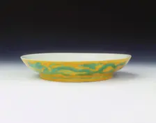Yellow saucer with dragons in green enamel, Zhengde period, Ming dynasty, China, 1506-1521. Creator: Unknown
