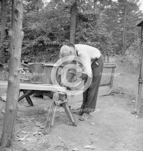 Zollie Lyons repairing the tobacco sleds at...harvest season, Wake County, North Carolina, 1939. Creator: Dorothea Lange.