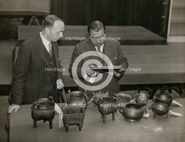 Zheng Tianxin (Dr F. T. Cheng) and Mr F.St. G. Spendlove examining exhibits, 1935. Creator: Topical Press Agency.