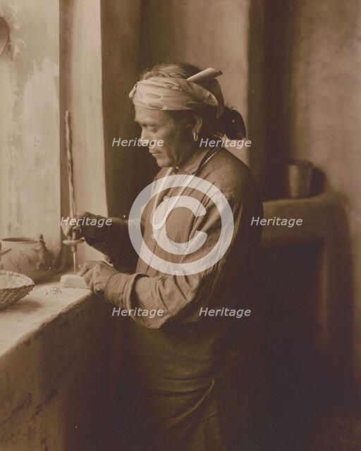 Zuni Indian bead worker drilling holes in beads, c1903. Creator: Edward Sheriff Curtis.